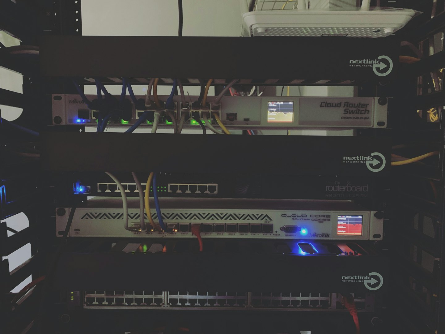 Server rack with active networking equipment and colorful cables.